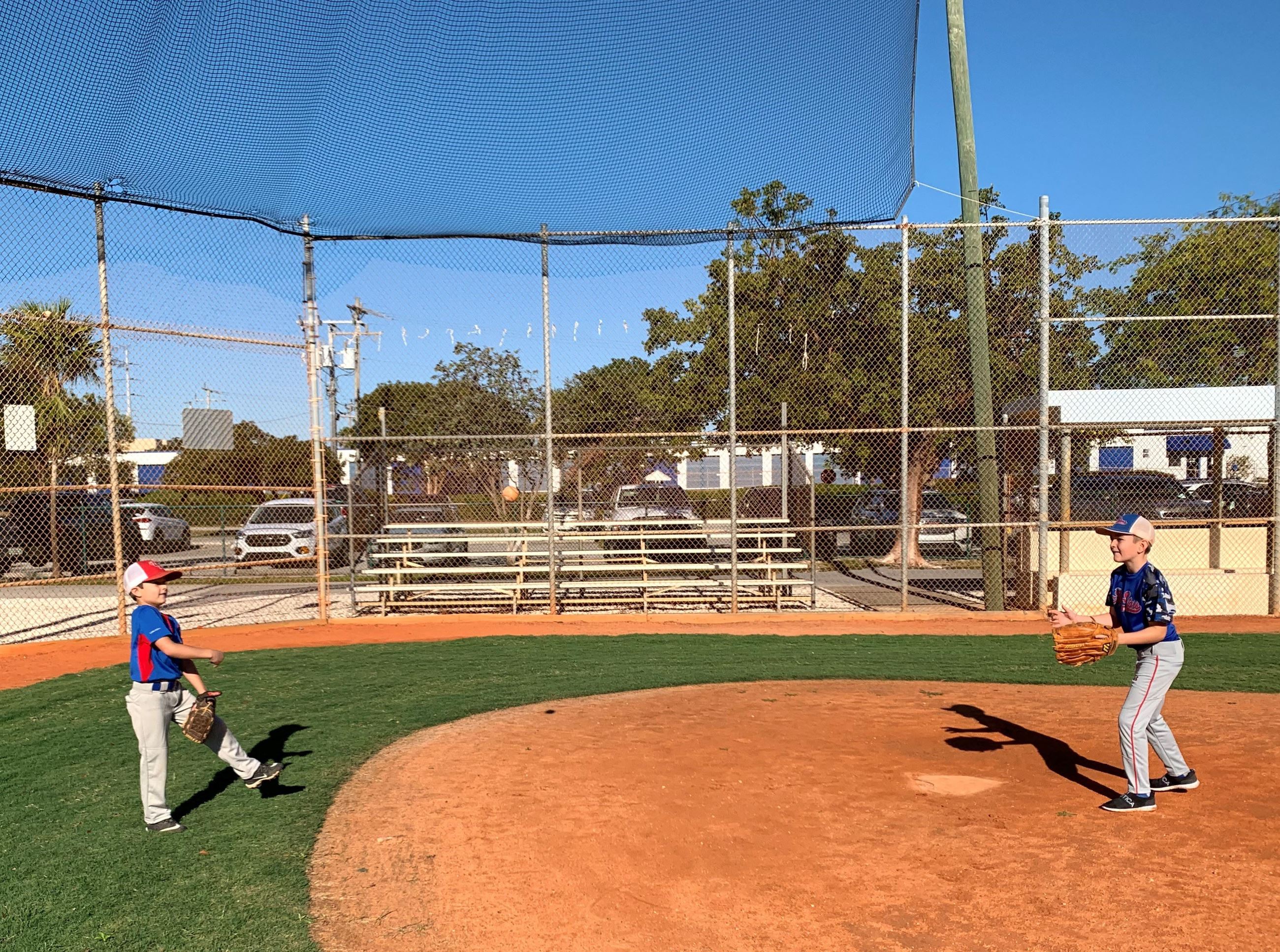 Two Upper Keys Little League players throw a ball to each other on the newly refurbished clay